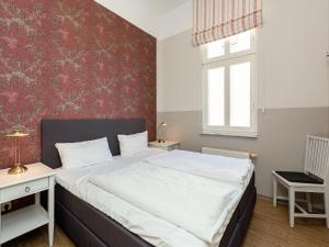 ein Schlafzimmer mit einem Bett und einer roten Wand in der Unterkunft Villa Amelia, App. 06 in Heringsdorf
