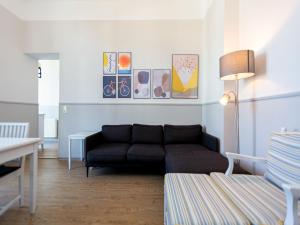 ein Wohnzimmer mit einer schwarzen Couch in einem Zimmer in der Unterkunft Villa Amelia, App. 07 in Heringsdorf