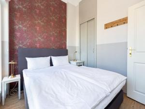 Schlafzimmer mit einem großen weißen Bett und einer roten Wand in der Unterkunft Villa Amelia, App. 07 in Heringsdorf