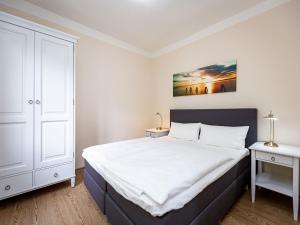 1 dormitorio con 1 cama grande y 2 mesitas de noche en Villa Amelia App 09, en Heringsdorf