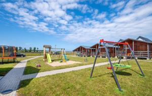 a park with a playground with slides and swings at Domki pod wzgórzem in Kopań