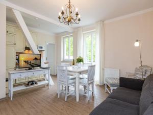 un soggiorno con tavolo bianco e TV di Villa Amelia App 12 a Heringsdorf