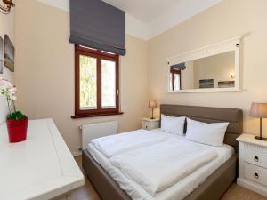 ein Schlafzimmer mit einem großen weißen Bett und einem Spiegel in der Unterkunft Villa Arcadia, App. 05 in Heringsdorf