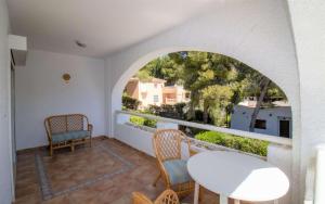 balcón con mesa, sillas y ventana en Villa con jardin y piscina privada ALCOSSEBRE Albert Villas en Alcocéber