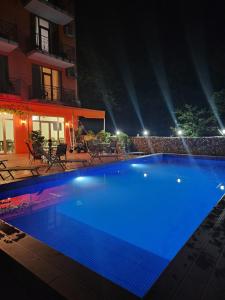 una gran piscina azul por la noche en Vizitori Hotel, en Gonio