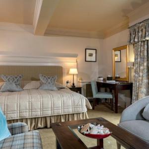 1 dormitorio con cama, escritorio y mesa en Isle of Eriska Hotel Spa & Island, en Benderloch