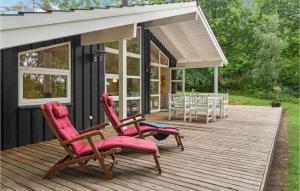 OddeにあるStunning Home In Hadsund With 3 Bedrooms, Sauna And Wifiのデッキに椅子2脚とテーブル1台が備わる家