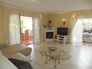 un soggiorno con un divano, un tavolo e una televisione di Villa Ambiente para 4 personas a Calpe