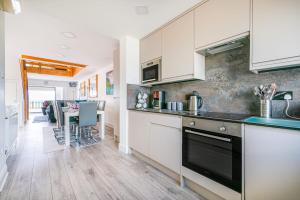 a kitchen with white cabinets and a counter top at Family Beachfront Bliss Sleeps 10 in Pevensey