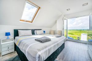 a bedroom with a large bed and a large window at Family Beachfront Bliss Sleeps 10 in Pevensey