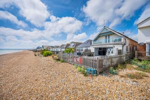 a row of houses on a rocky beach at Family Beachfront Bliss Sleeps 10 in Pevensey