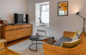 ein Wohnzimmer mit einem Sofa, einem TV und einem Tisch in der Unterkunft Stunning Home In Plouguerneau With Kitchen in Plouguerneau