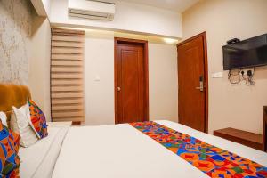 a bedroom with a bed and a flat screen tv at FabHotel Divine Casa in Bhopal