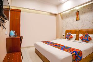 ein Hotelzimmer mit einem Bett und einem TV in der Unterkunft FabHotel Divine Casa in Bhopal