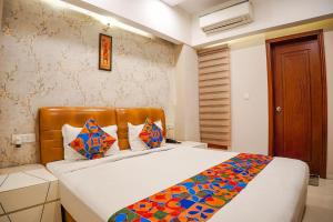 ein Schlafzimmer mit einem Bett mit einer bunten Decke darauf in der Unterkunft FabHotel Divine Casa in Bhopal