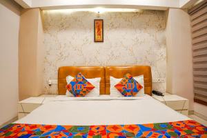 Schlafzimmer mit einem Bett mit einem braunen Lederkopfteil in der Unterkunft FabHotel Divine Casa in Bhopal