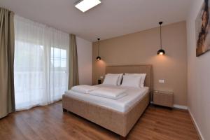 een slaapkamer met een groot bed en een groot raam bij Villa Sophia with private swimming pool near the beach! in Zakučac