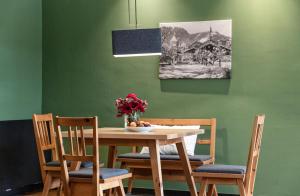 une table à manger avec des chaises et un vase de fleurs dans l'établissement Kitzbühel Residences, à Kitzbühel