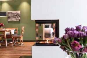 a fireplace in a living room with purple flowers at Kitzbühel Residences in Kitzbühel