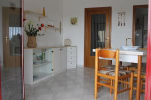 マリーナ・ディ・モーディカにあるCicciuri Relax - fronte mareのキッチン(シンク、テーブル、椅子付)
