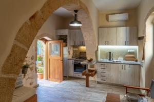 una cocina con un arco con fregadero y barra en convexa domus, en Pazinos