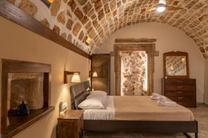 una camera con letto e muro di mattoni di convexa domus a Pazinos