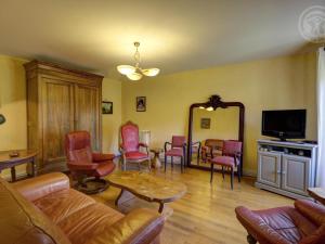 ein Wohnzimmer mit einem Sofa, Stühlen und einem Spiegel in der Unterkunft Gîte Saint-Symphorien-de-Lay, 3 pièces, 4 personnes - FR-1-496-278 in Saint-Symphorien-de-Lay