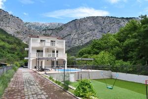 een huis met een zwembad en bergen op de achtergrond bij Villa Sophia with private swimming pool near the beach! in Zakučac
