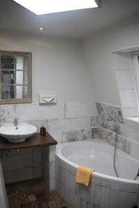 a white bathroom with a tub and a sink at Boulevardhotel Sängerstadt - alle Zimmer klimatisiert in Finsterwalde