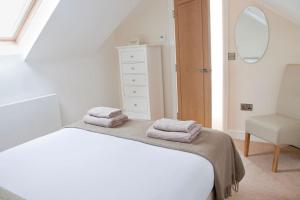 um quarto com uma cama, um espelho e uma cadeira em Beautiful 3 bedroom house, central Harrogate em Harrogate