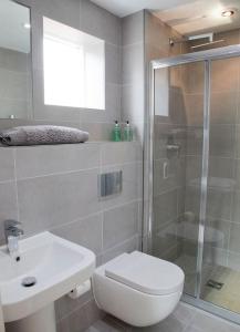 y baño con ducha, aseo y lavamanos. en Beautiful 3 bedroom house, central Harrogate, en Harrogate