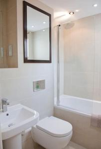 a white bathroom with a toilet and a sink at Beautiful 3 bedroom house, central Harrogate in Harrogate