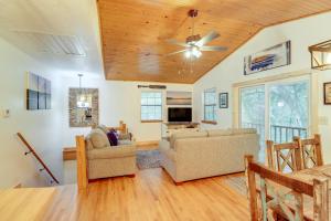 a living room with two couches and a ceiling fan at Woodsy Gassville Getaway about 3 Mi to White River! in Gassville
