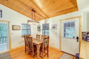 a dining room with a wooden table and chairs at Woodsy Gassville Getaway about 3 Mi to White River! in Gassville +24 photos