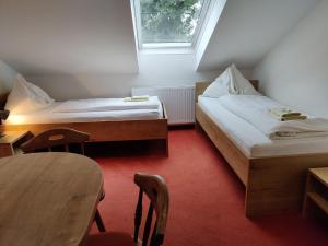 ザンクト・ゲオルゲン・イム・アッターガウにあるPension Holzapfelのベッド2台とテーブルが備わる小さな客室です。