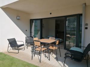 a patio with a wooden table and chairs at A GAUGUIN Cyclistes Ventoux in Malaucène