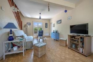 a living room with a flat screen tv and a couch at Vacances paisibles tout près de l'océan in Piriac-sur-Mer