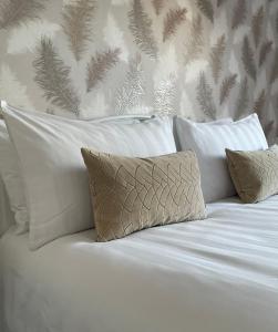 a white bed with white pillows and a wall at Apartment 33 Lytham in Lytham St Annes