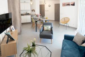 a living room with a blue couch and a table at LE COCON TRESUM - Lac, Vieille ville, Garage in Annecy