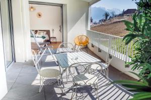 einen Balkon mit einem Tisch, Stühlen und einem Bett in der Unterkunft LE COCON TRESUM - Lac, Vieille ville, Garage in Annecy