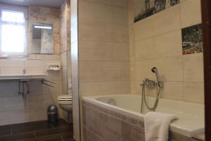 a bathroom with a tub and a toilet at Boulevardhotel Sängerstadt - alle Zimmer klimatisiert in Finsterwalde