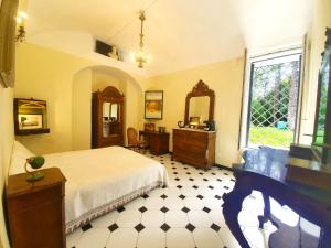 um quarto com uma cama, uma secretária e uma janela em Villa De Benedetti em Sarzana
