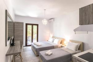 une chambre d'hôtel avec deux lits et une cuisine dans l'établissement STRAWBERRY Skiathos, à Agia Paraskevi