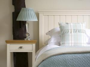 a bedroom with a bed with a lamp on a night stand at The Sparsholt Barn in Wantage