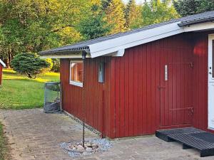 ein rotes Gebäude mit einer Tür und einem Fenster in der Unterkunft 6 person holiday home in F rvang in Fårvang