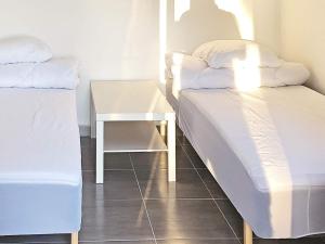 2 Betten in einem Zimmer mit Nachttisch und Tisch in der Unterkunft 6 person holiday home in F rvang in Fårvang