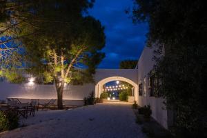 a white building with an archway at night at Pozzo Traverso Casale in Leporano Marina