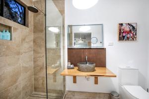uma casa de banho com um lavatório e um chuveiro em Airlie Beach Eco Cabins - Adults Only em Airlie Beach