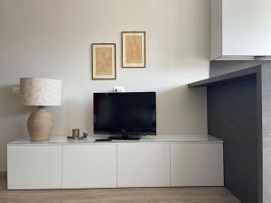 uma sala de estar com uma televisão num armário branco em SUITE DE ROLANDIS CirOO5005OO199 em Asti