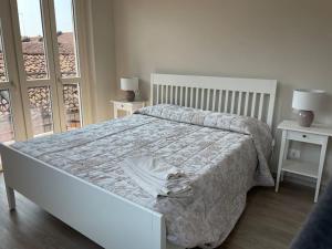 um quarto com uma cama e duas mesas e uma janela em SUITE DE ROLANDIS CirOO5005OO199 em Asti